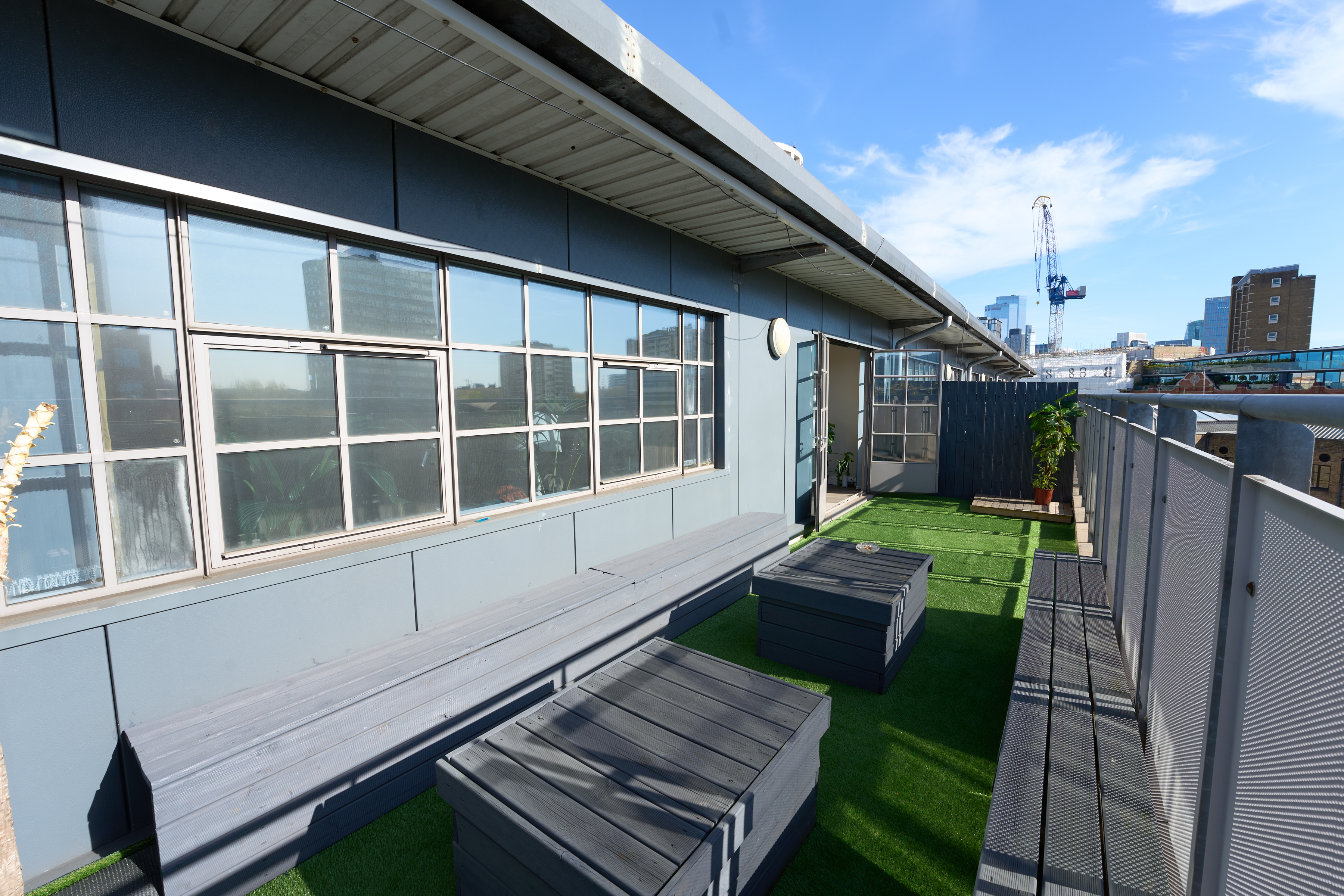Rooftop terrace with synthetic grass and London skyline view at The Designer's Penthouse